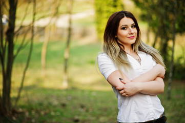 Portrait of girl with streaked hair, wear on white blouse, showing her shoulders.