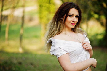 Portrait of girl with streaked hair, wear on white blouse, showing her shoulders.
