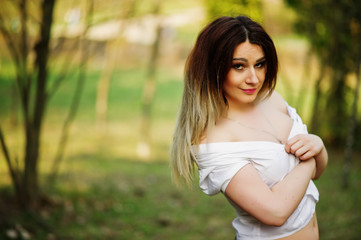 Portrait of girl with streaked hair, wear on white blouse, showing her shoulders.