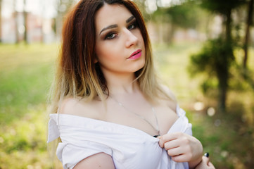 Portrait of girl with streaked hair, wear on white blouse, showing her shoulders.