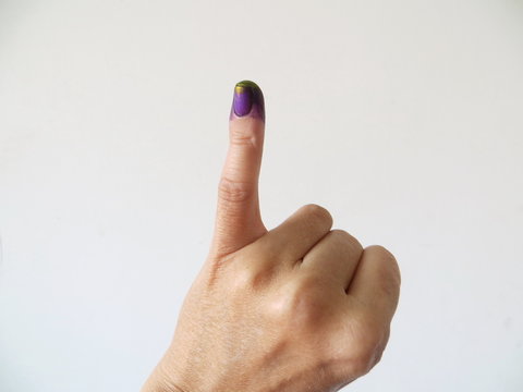 Inked pinky finger of a woman's hand. Purple ink blots from voter's finger provides evidence of the governor election (pilkada) in Jakarta, Indonesia.