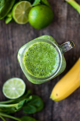 Green smoothie with lime, spinach and banana in a jar. Top view