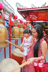 Asian woman and her daugther hit drum and bell in Chinese new year festival