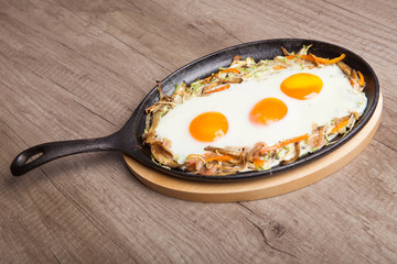Healthy traditional breakfast - Fried eggs with vegetables in pan.
