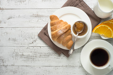 Croissant jam coffee at white wooden table. 