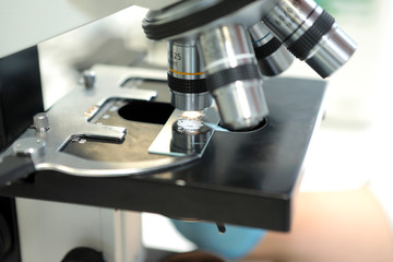 Medical microscope. Professional pharmaceutical microscope. Study of the properties of the drug when increasing. The person analyzes the components of the medicine.