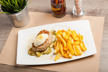 Roasted pork knuckle with served in a plate French fries and sour cream