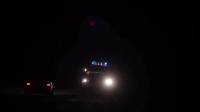 Car rescuers truck flashing blue lights at night, fire truck on road with lights on and siren