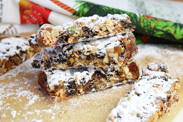 Italian Christmas dessert with nuts and candied fruits in a sugar powder with Christmas background. Holiday concept, Traditional food