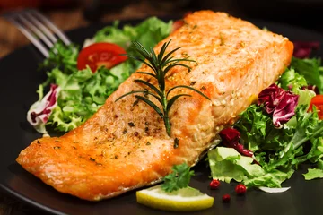 Photo sur Plexiglas Plats de repas Baked salmon served with fresh vegetables.