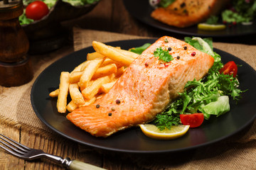 Baked salmon served with french fries.