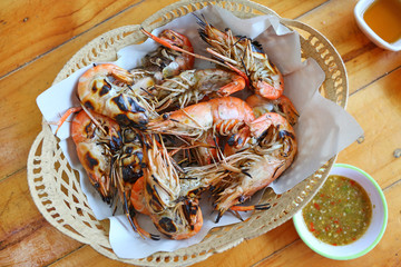 Grilled Prawns in basket with spicy sauce on wood table