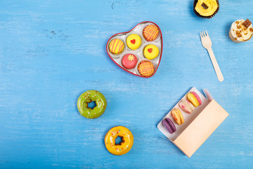 Glazed donuts, Macaroons and Cupcakes. Sweet dessert. Cakes with nuts cream. Almond macaron cookies in heart-shaped box.