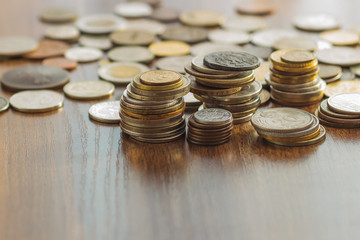 Different gold and silver collector's coins on the wooden table