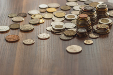 Different gold and silver collector's coins on the wooden table