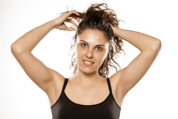 Fototapeta premium beautiful young woman adjusts her curly hair in a ponytail