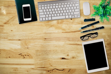 Office desk table with computer, supplies,analysis chart, ipad,smartphone,coffee cup on wooden background. Top view with copy space