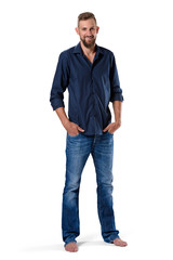 Portrait of tall young man with beard in blue shirt and jeans