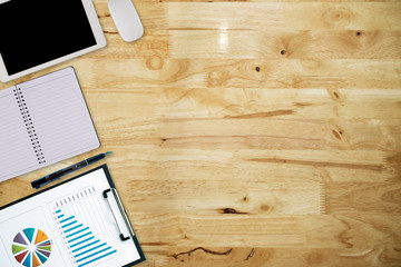 Office desk table with computer, supplies,analysis chart, ipad,smartphone,coffee cup on wooden background. Top view with copy space