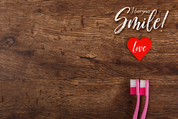 Lesbian couple love concept with heart and toothbrushes. Valentines day design on wood vintage background. Love your smile.