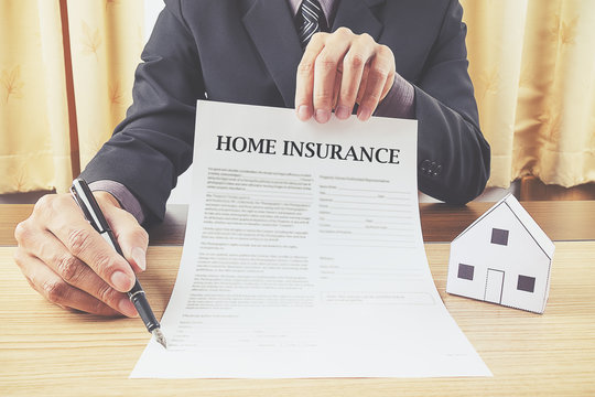 house representing home ownership and the Real Estate business on a contract for house sale, lease, insurance or mortgage in a real estate concept, viewed low angle with focus to the tip.