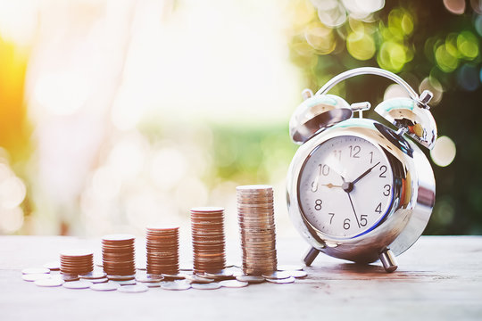 Close up of time and money with green bokeh background ,Business Finance and Money concept,Save money for prepare in the future.time is money concept