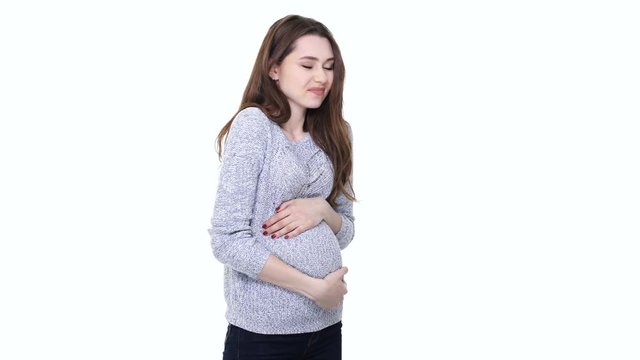 Tired worried pregnant woman touching her belly and feeling exhausted isolated over white