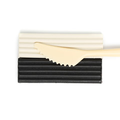 Black and white plasticine and cutting knife isolated on white background