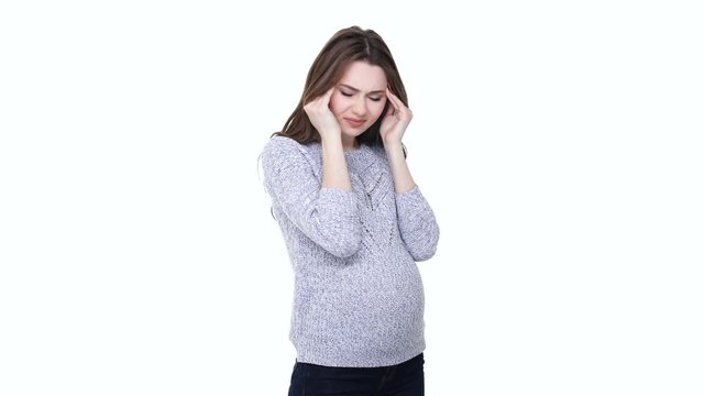 Stressed young pregnant woman suffering from headache and touching her belly isolated on white