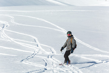 Fototapeta na wymiar snowboarder snowboarding on fresh snow on ski slope on Sunny winter day in the ski resort in Georgia's