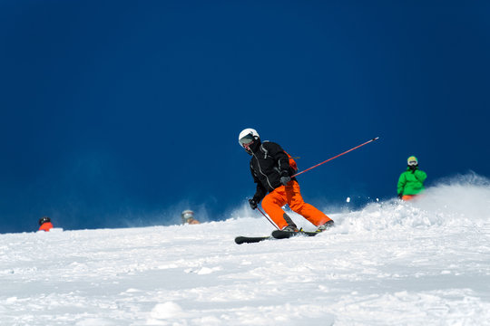 A skier during descent at a ski resort. Beautiful winter landscape with snow-topped mountains.