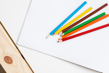 Multicolored pencils lying on a white table