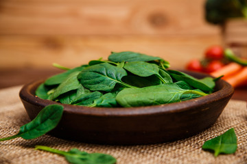 Spinach leaves in bowl. Raw fresh vegetable. Fresh natural plant leaf. Organic bio food on rustic...