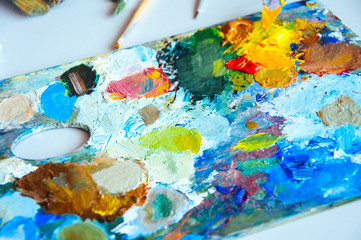 Fototapeta premium Art brushes and palette with oil paints on a table. Painting concept.