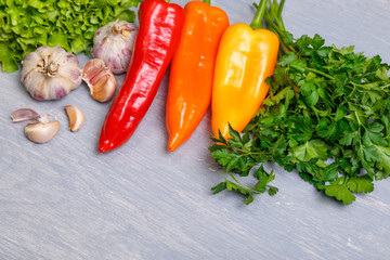 Fresh vegetables. Pepper, green salad and garlic, parsley. Fresh natural food. Organic vegetables on wooden background.