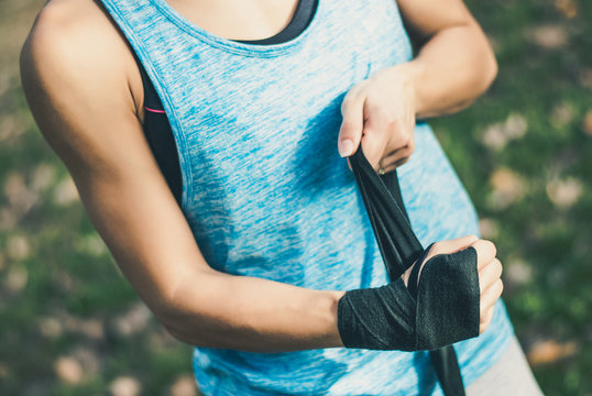 Young Fitness Lady Putting On A Sport Gloves In Park