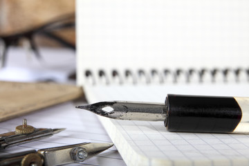 Dividers and the old penholder with the pen lies on the notebooks sewn with metal springs on a...