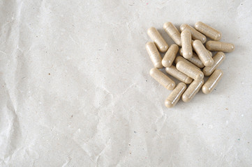 A pile of pills on a brown paper, large copy space