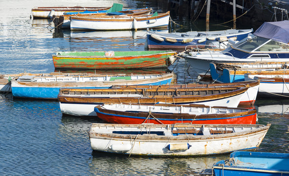 Colored wooden boats on the sea in Naples, Italy 