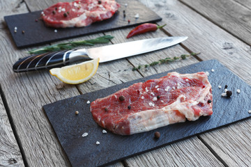 Raw beef steak on dark wooden table background
