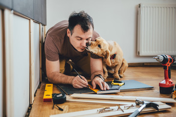 Man and his dog doing renovation work at home