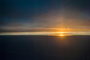 View of the sunrise and the clouds from within, out of the plane