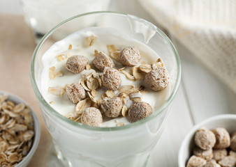Wheat bran and oat flakes in yogurt closeup shot