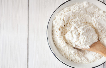 Making dough, baking. Bowl with flour on wood desk