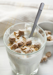 Yogurt with granola on a wooden table, vertical, selective focus