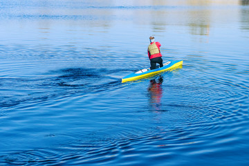 Woman paddling with canoe on the blue river on a sunny day. Young women canoeing. Kayak. People kayaking in the river Dnieper. Activities on the water. 