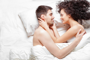 happy beautiful young couple lying on the bed