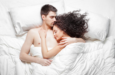 Top view of young couple sleeping on the bed