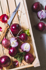 Freshly harvested red onion bulbs in wooden farmers box