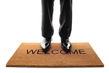 Pair of legs standing on a doormat